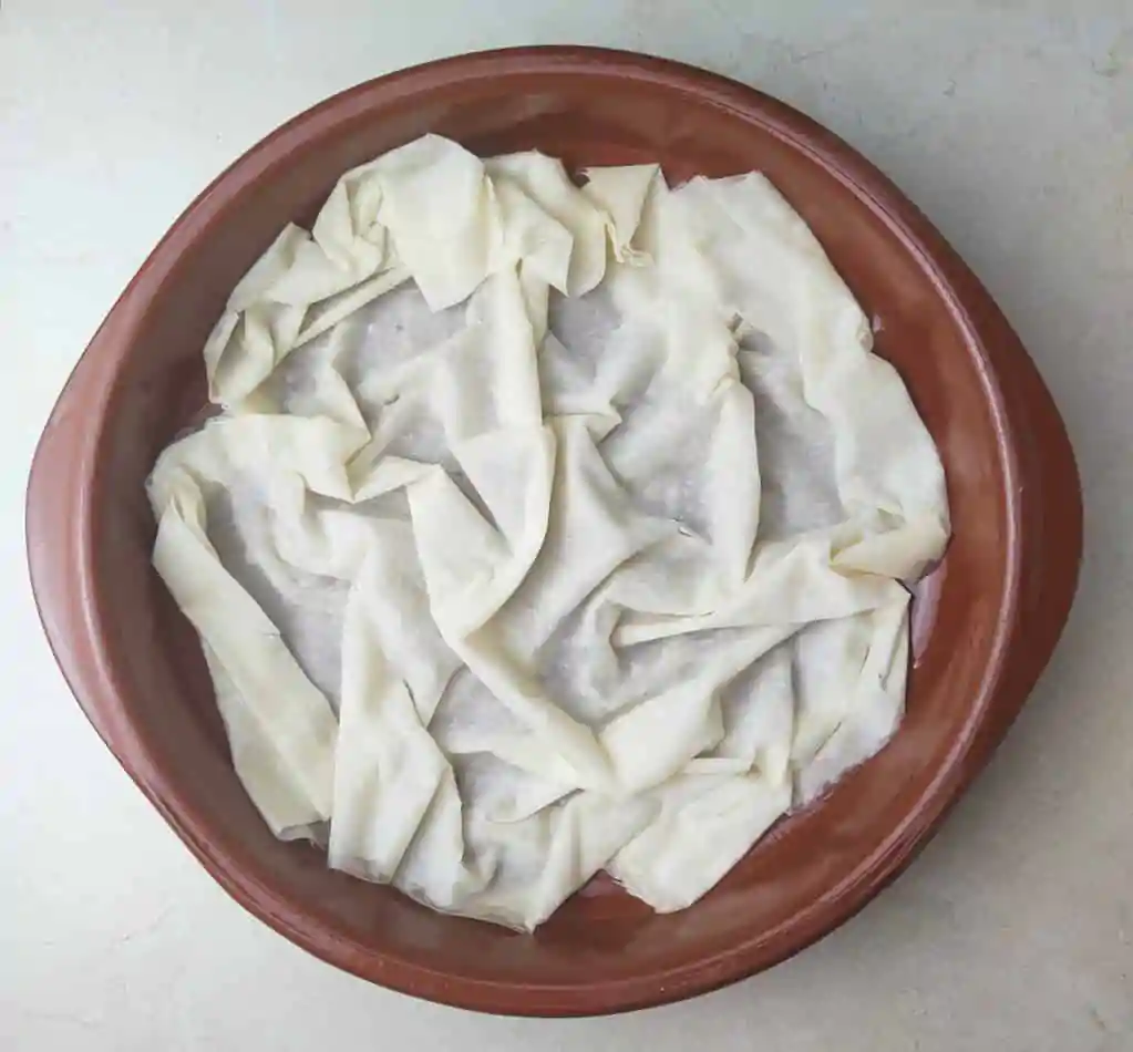 image showing how to place the phyllo sheet at the bottow of the pie pan 