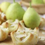 brie and pear puff pastry bites served with honey and sliced almonds