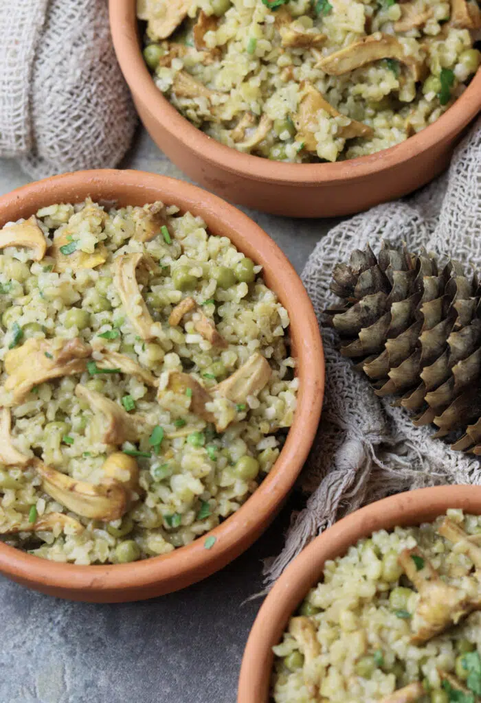 Bulgur risotto with chanterelles served in cute brown bowls. 