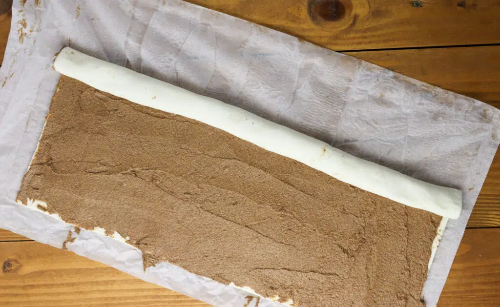 image showing how to roll the sheet filled with cinnamon filling 