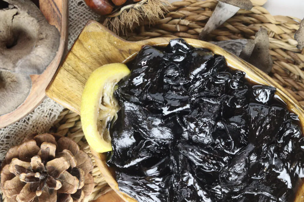 image of delicious black trumpet mushroom jam with lemons, decorated with pine cones